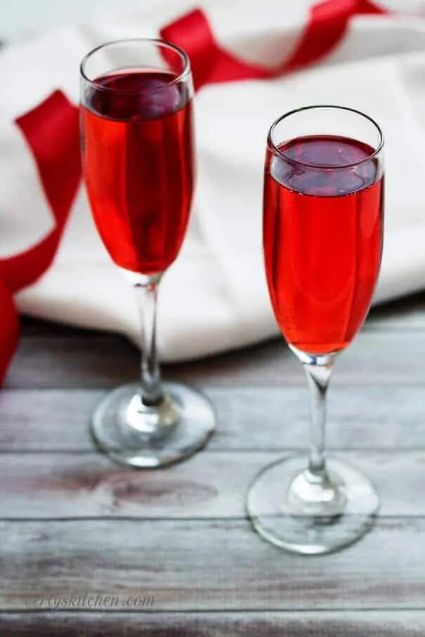 Champagne grenadine spritzer with a white napkin and red and white ribbons.