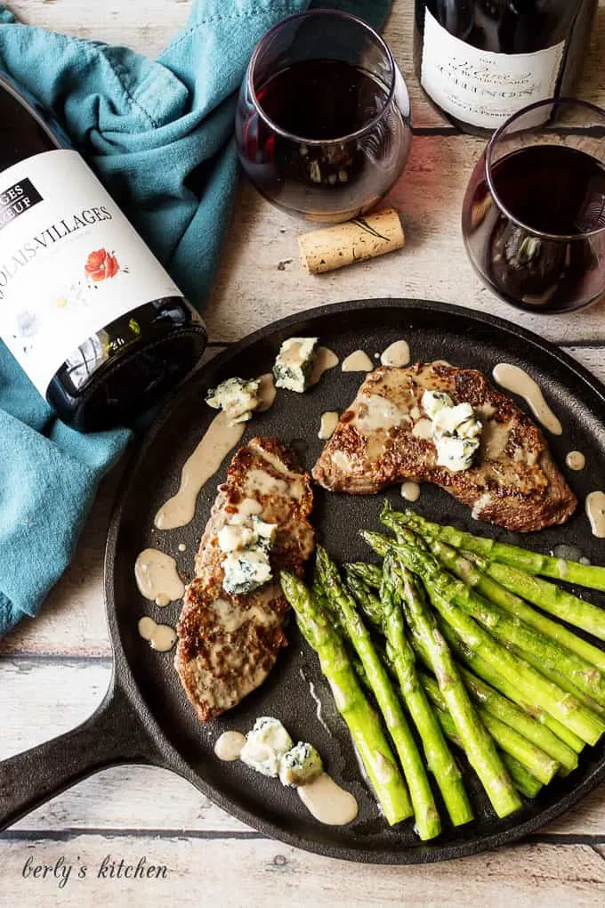 Top down view of steak, asparagus, blue cheese sauce with red wine.