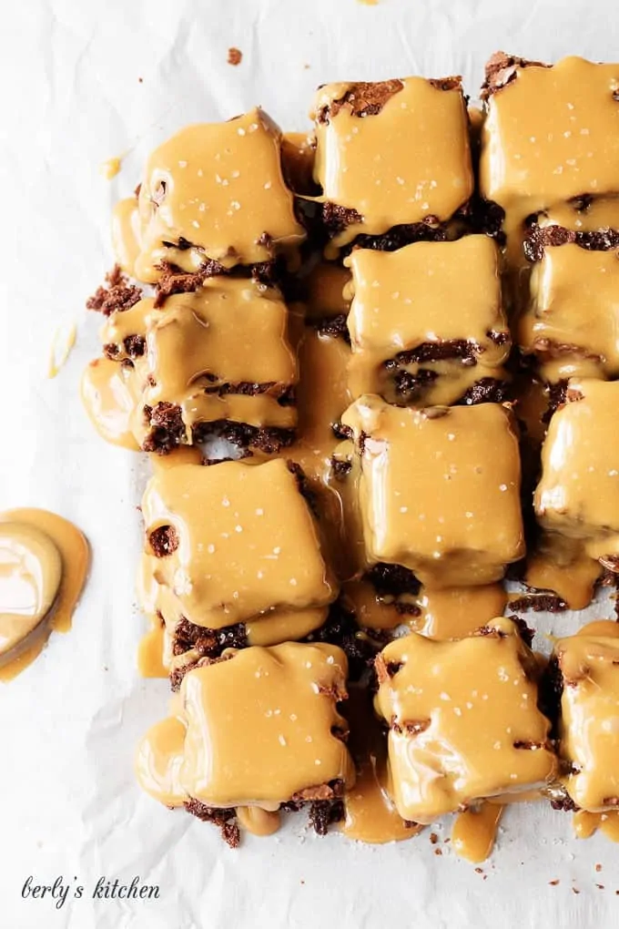 Brownies with salted caramel sauce on parchment paper.