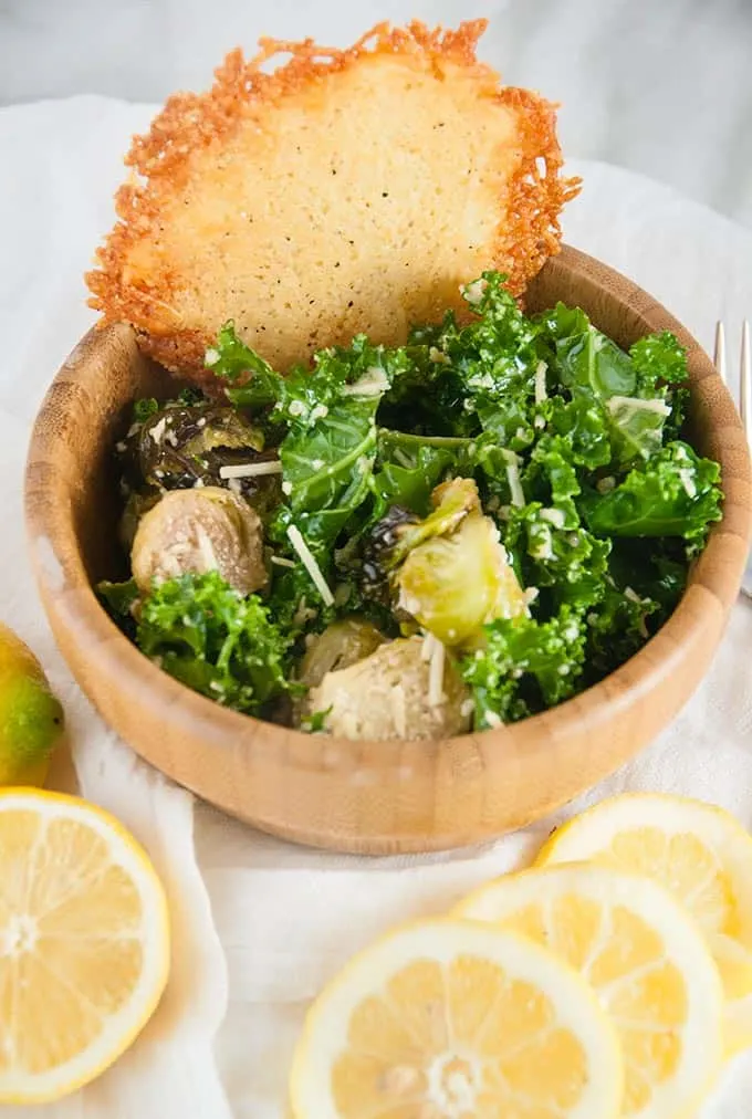 Close up of brussels sprouts salad with parmesan crisp and lemon slices.