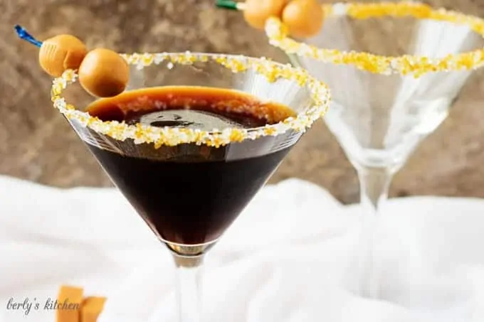 Salted caramel coffee martini with "caramel olives" in a long-stemmed martini glass.