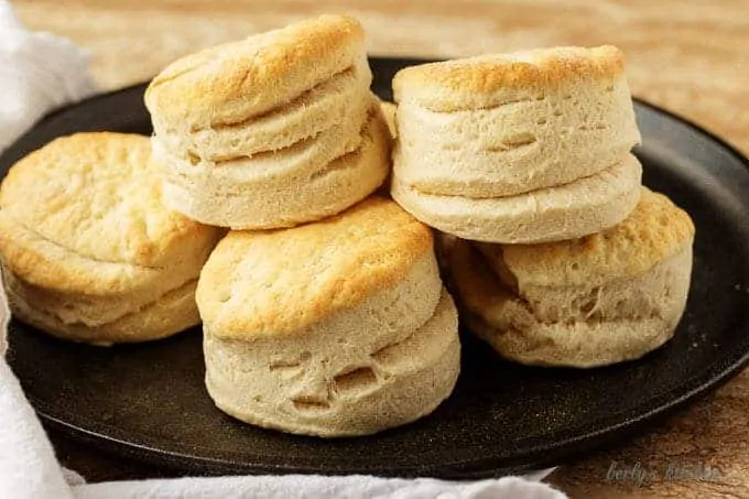 Pile of homemade buttermilk biscuits on cast iron.