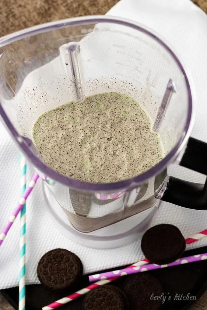 Top-down view of the ingredients mixed in a blender surrounded by cookies.