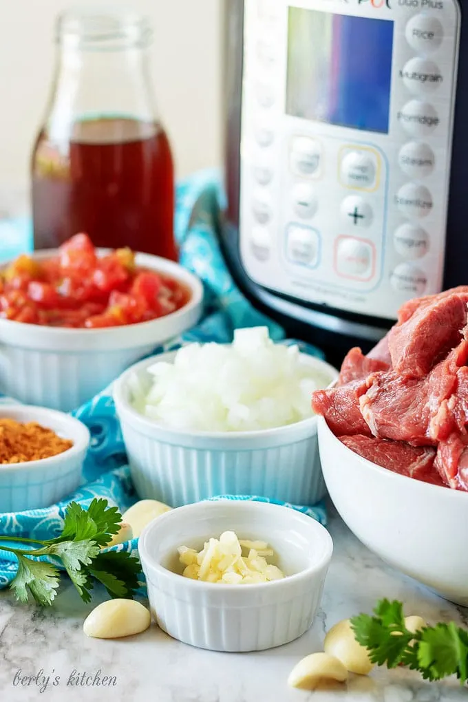 Beef broth, onions, garlic, taco seasoning, and beef used in shredded beef tacos.