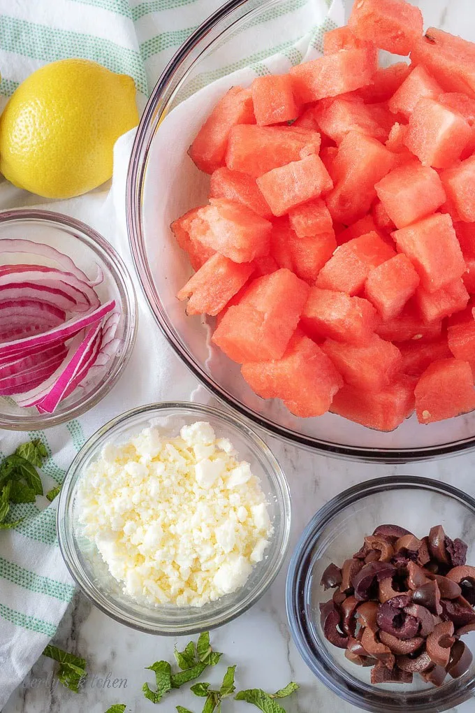 A top-down photo of the watermelon salad ingredients like watermelon, feta, and sliced red onion.