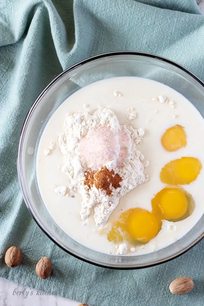 A mixing bowl showing the flour, milk, eggs, and ground nutmeg added for mixing.