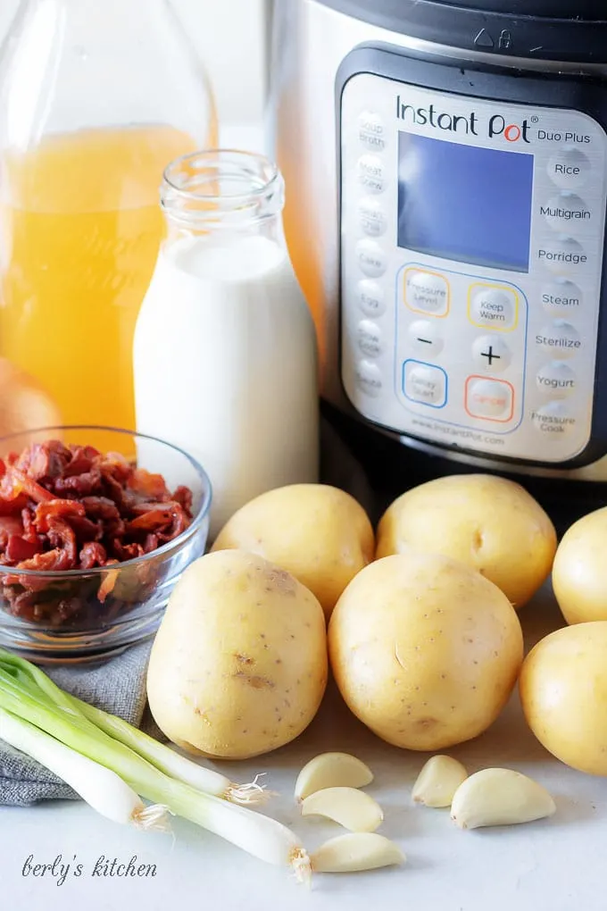 All of the potato soup with bacon ingredients, like cooked bacon and heavy cream, prepped to create the dish.