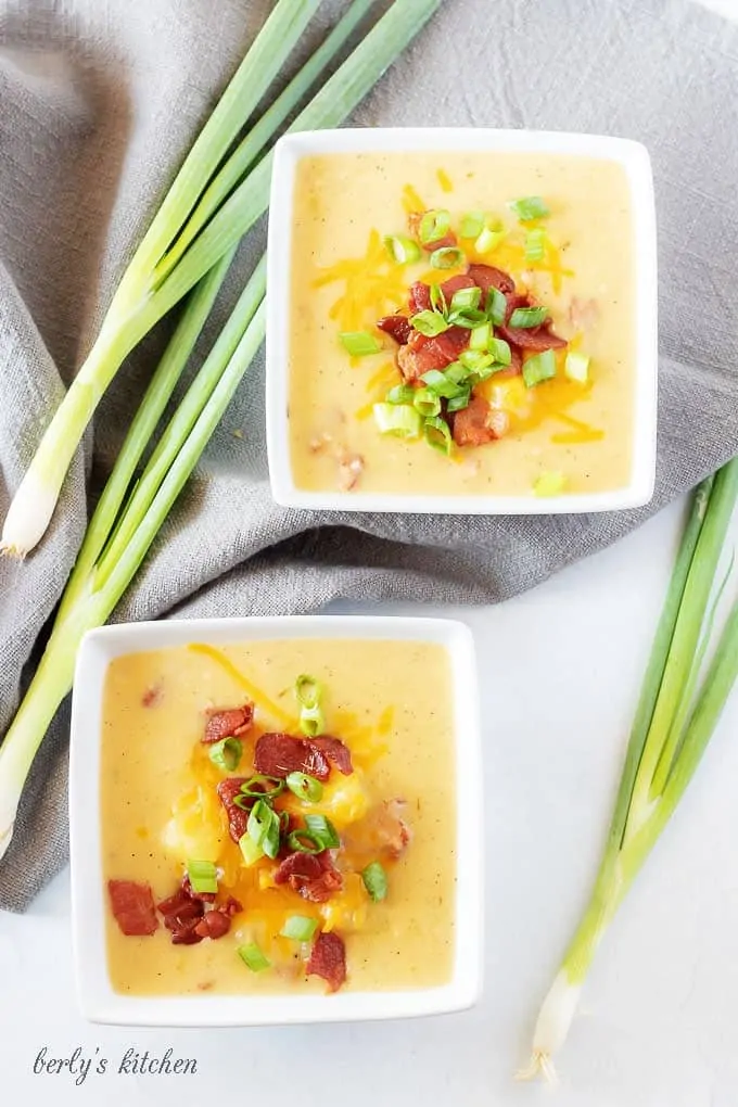 A final top-down picture if the finished instant pot potato soup with bacon served in two squares bowl.