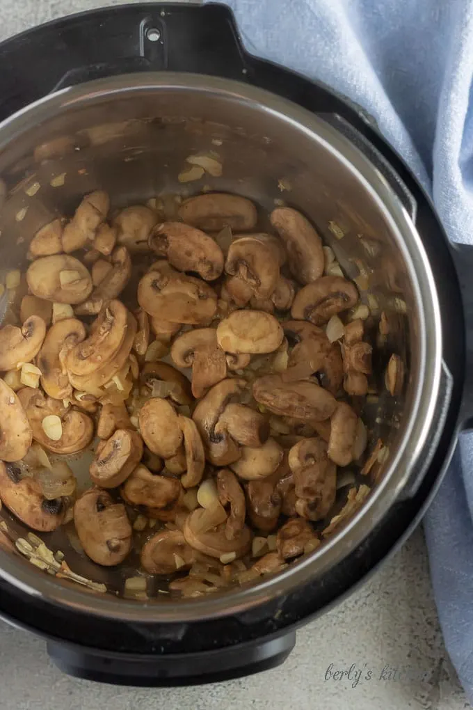 Another top-down picture of the mushrooms, onions, and garlic, cooking inside the instant pot.