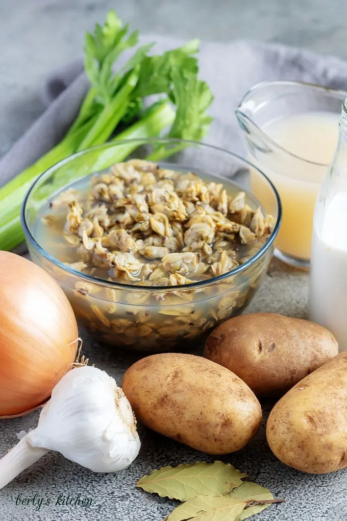 The clam chowder recipe ingredients like clams, onions, garlic, and potatoes.