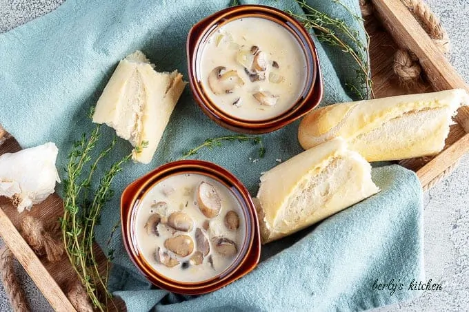 The finished easy mushroom soup served in two earthen ware bowls with a side of bread.