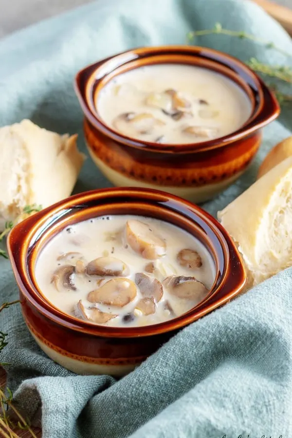 A large picture showing the easy mushroom soup in earthenware bowls served with crusty french bread.