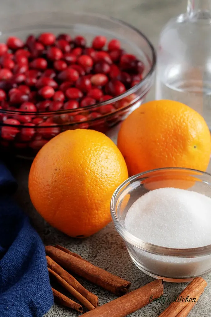 The homemade cranberry sauce ingredients, like sugar, oranges, and cranberries.