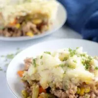 A large picture of the finished shepherd's pie on a plate, garnished with chives and ready to serve.