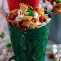 Christmas chex mix in red, green, and silver tins.