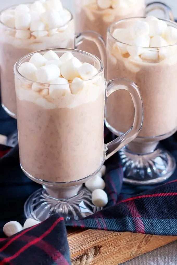 4 mugs of instant pot hot cocoa topped with marshmallows.