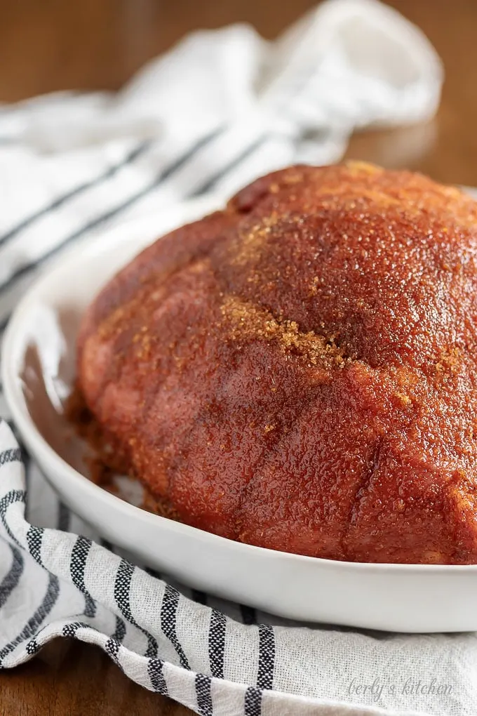 A close-up view of the pork shoulder coated with a dry rub.