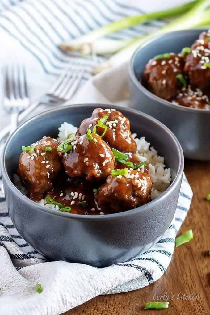 Instant pot teriyaki meatballs with rice in two gray bowls.