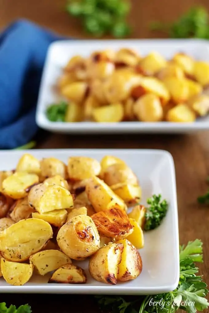 Two bowls of garnished ranch potatoes, ready to be served.