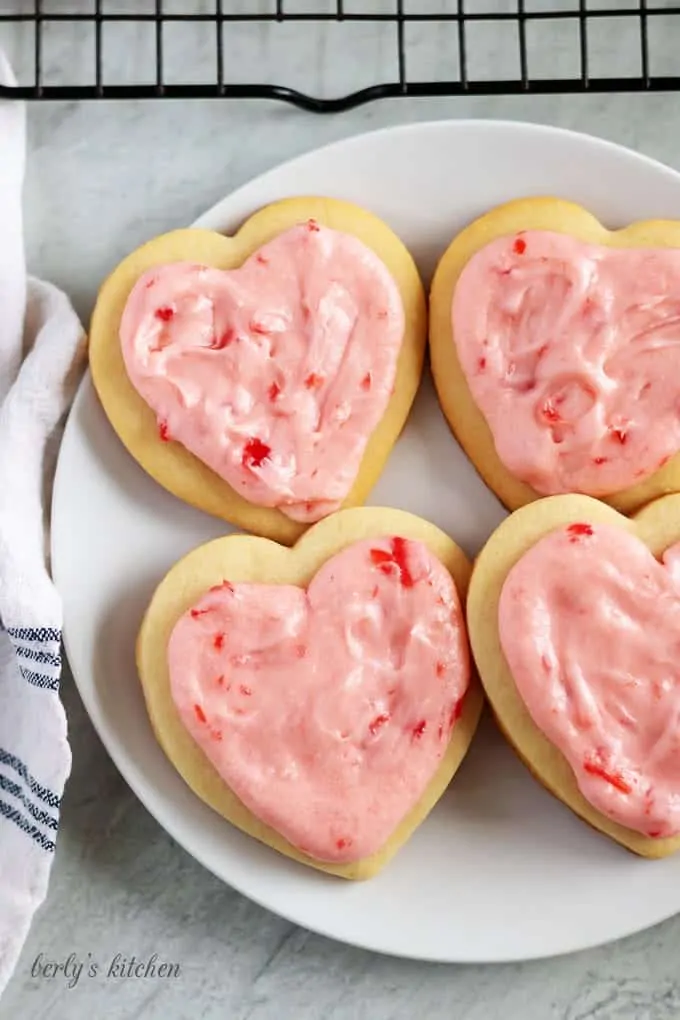 Top down view of 4 cut out sugar cookies on a plate.