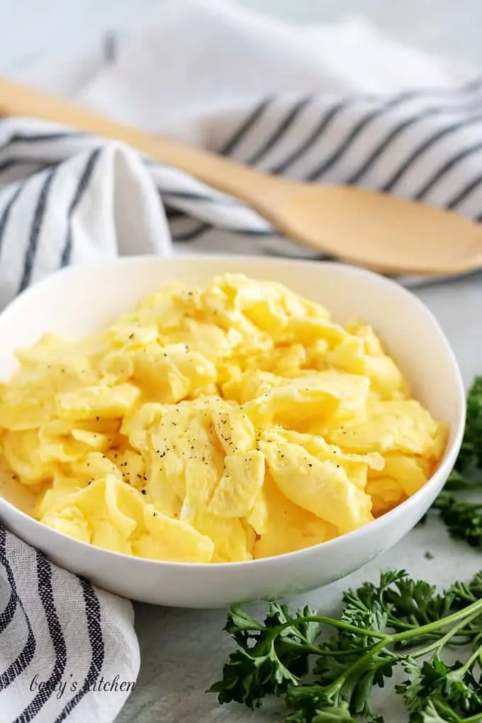 A final shot of the fluffy scrambled eggs in a white bowl.