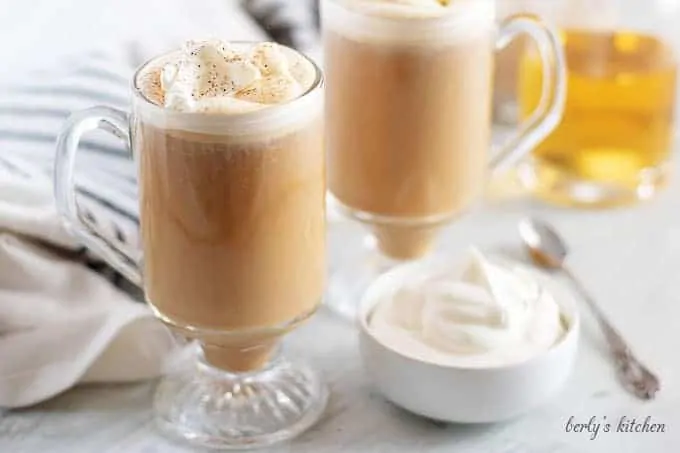 Two nutty irishman drinks, in mugs, garnished with homemade whipped cream.