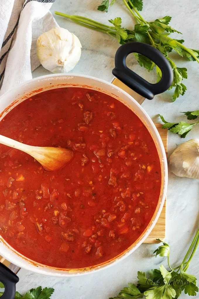 A top-down photo of the crushed tomatoes and tomato paste simmering.