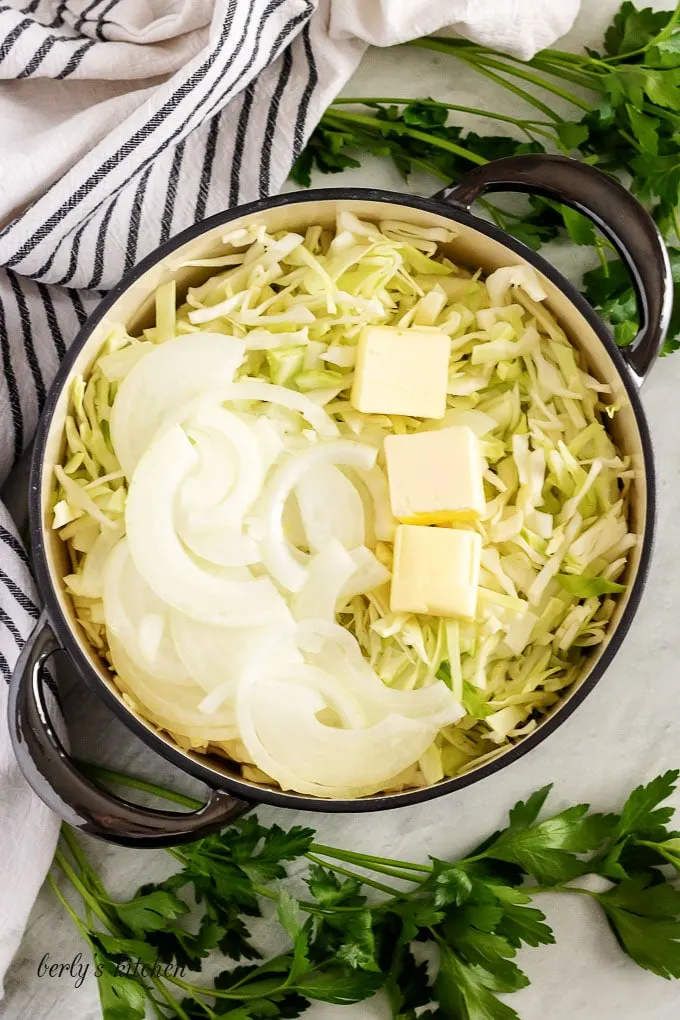 Shredded cabbage, onions, and butter, in a pan for frying.