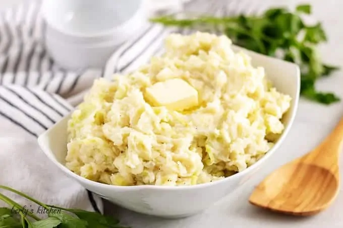 The finished colcannon recipe, in a bowl, topped with butter.