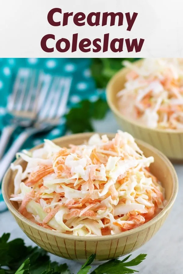 Two small bowls of creamy coleslaw with forks sitting nearby.