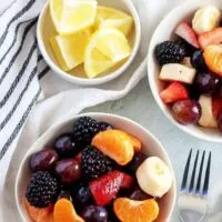 An aerial photo of two bowls filled with homemade fruit salad.