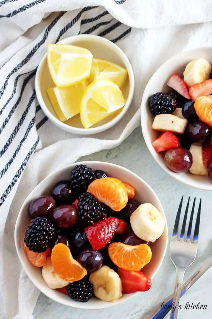 An aerial photo of two bowls filled with homemade fruit salad.