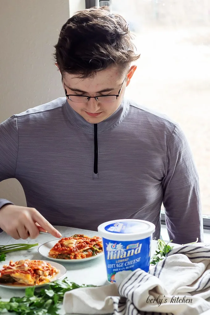 My son, at the kitchen table, enjoying the mushroom lasagna.