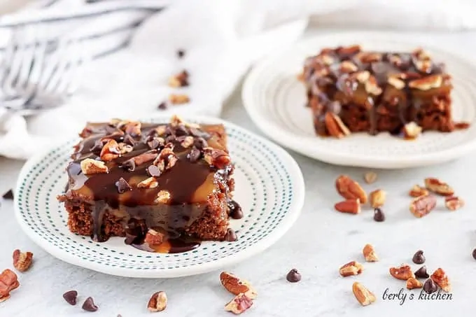 Two turtle brownies covered in chocolate ganache and sweet caramel.