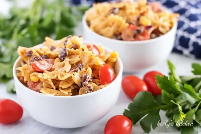 Two bowls of southwest pasta salad accented with fresh grape tomatoes.