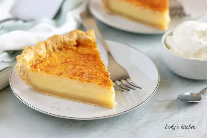 A slice of the buttermilk pie sitting on a white plate.