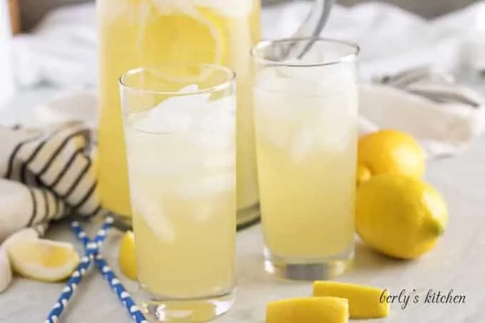 A pitcher and two glasses filled with ice and instant pot lemonade.