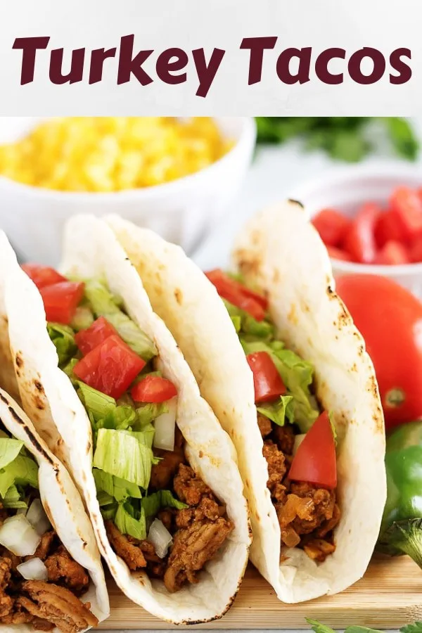 A close-up shot of the turkey tacos surrounded by fresh tomatoes.