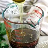 A tablespoon of honey being added to the soy sauce.