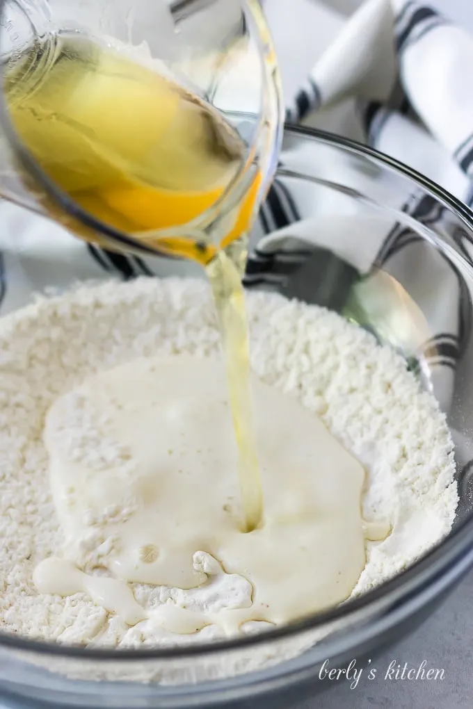 The ale being added to the dry ingredients to create the batter.