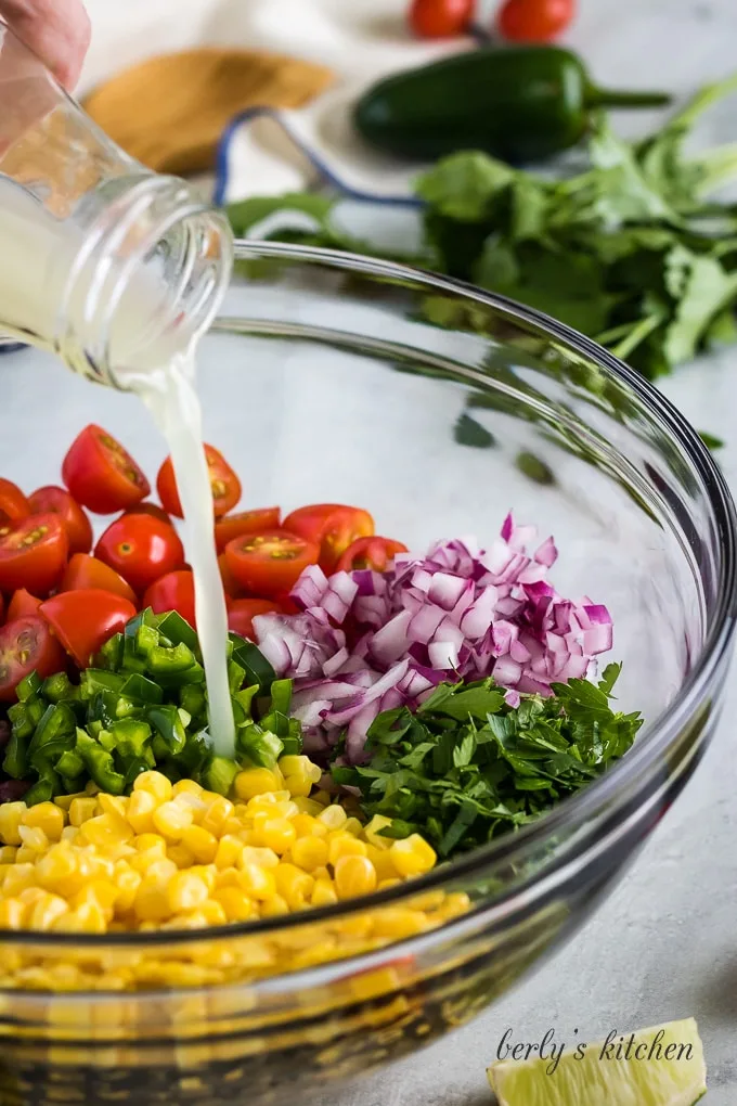 Fresh squeezed lime juice being poured over all of the ingredients.