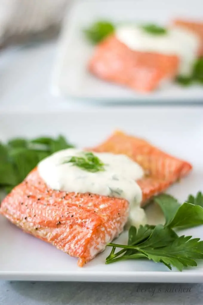 The last photo shows the finished salmon on a plate with sauce.