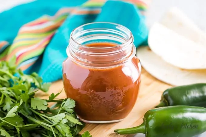 The red enchilada sauce in a mason jar accented with jalapenos.