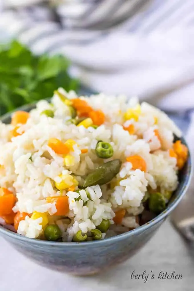 The pressure cooker rice served in a decorative blue bowl.