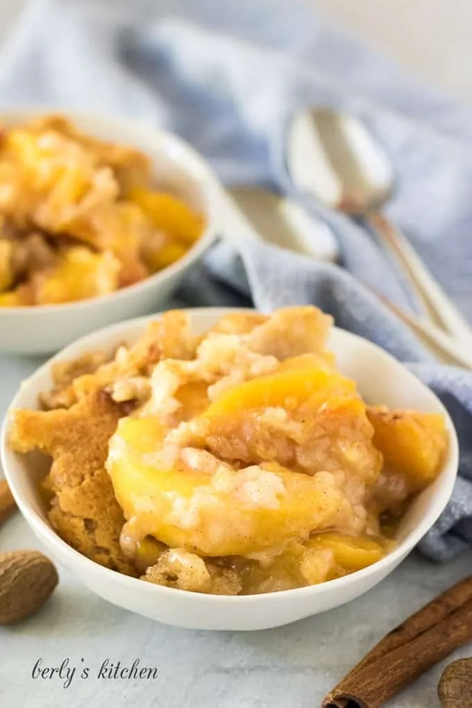 The finished peach cobbler is being served in white bowls.