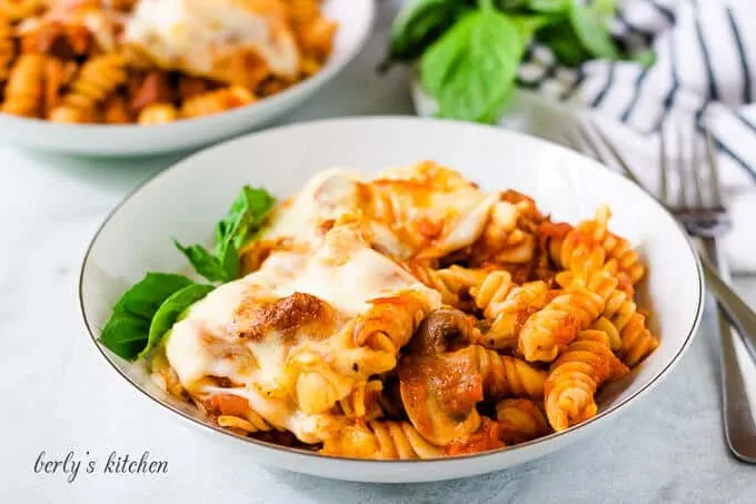 The finished cheesy pasta bake served in a white bowl.