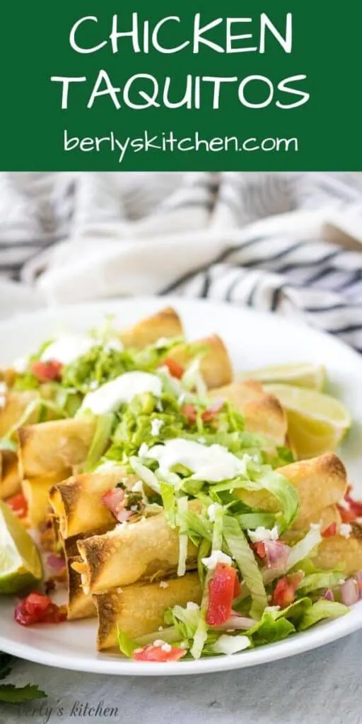 A plate of chicken taquitos served with lettuce, tomatoes, and sour cream.