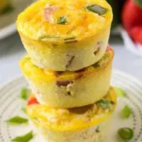 Three stacked egg muffins sitting on a small decorative plate.