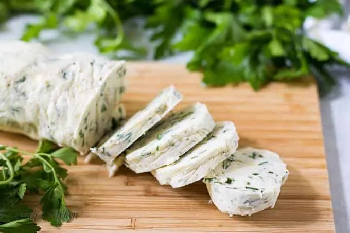 A log of the garlic herb butter sliced for use.