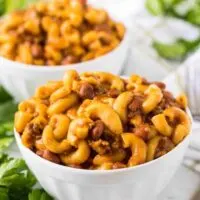 The finished chili mac served in large white bowls.